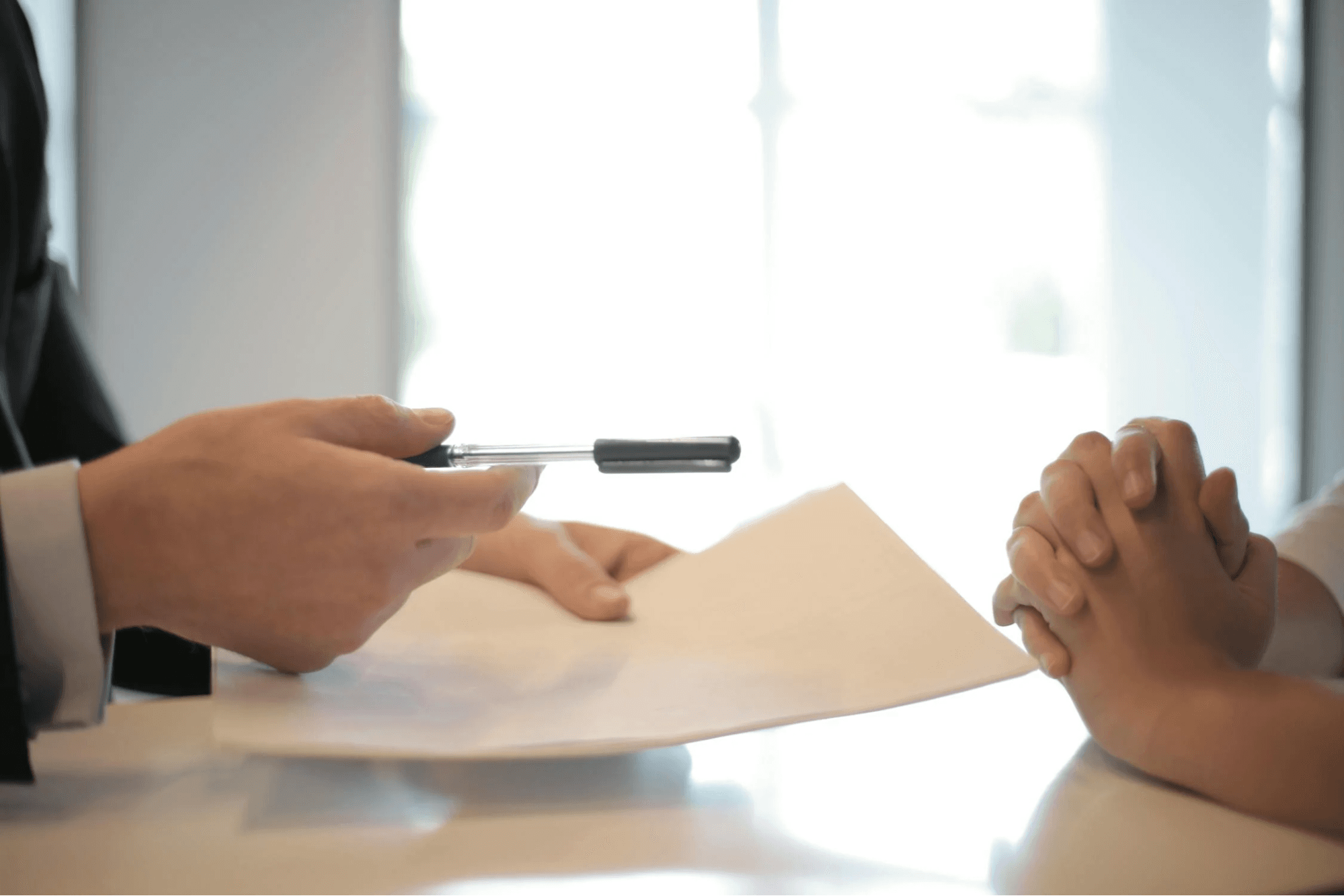 Deux personnes signent un document administratif dans un bureau, illustrant la souscription d’assurances pour médecins en exercice libéral.