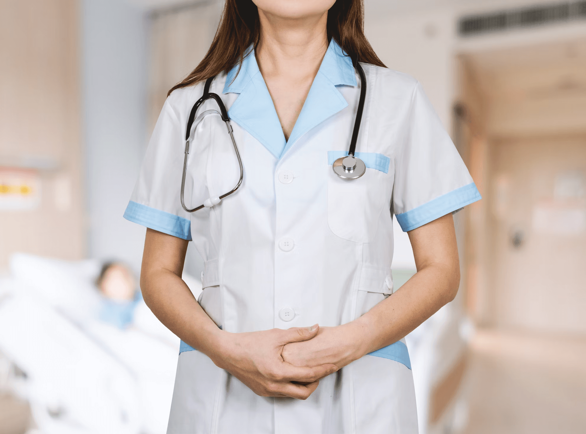 Une infirmière en blouse les mains jointes avec un stéthoscope autour du coup